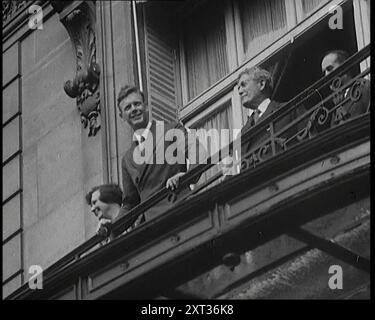 Charles Lindbergh und Anne Morrow Lindbergh auf einem Balkon winkten der Presse und den Menschenmassen, 1927. Der amerikanische Flieger Charles Lindbergh und seine Frau erscheinen auf ihrem Hotelbalkon, nachdem Lindbergh den ersten erfolgreichen Transatlatikflug von New York nach Paris absolviert hatte. Aus "Time to Remember - Fast and Far in the zwanziger Jahre", 1927 (Rolle 3); ein Blick auf die Besessenheit von Geschwindigkeit und Reisen in den späten 1920er Jahren Stockfoto