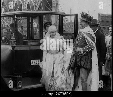 Die Schauspieler Emil Jannings und Henny Porten trachteten sich in historischen Kostümen und stiegen aus einem Auto, während sie von anderen deutschen Schauspielern umgeben waren, am Set von Anne Boleyn, 1920er Jahre Filmproduktion von Ann Boleyn, von Believe IT or Not. Regisseur Ernst Lubitsch machte nicht nur gute Filme, sondern verwendete auch ein britisches Thema für sein Drehbuch. Der Star des Films ist der Schauspieler Emil Jannings als Heinrich VIII. Für Elstree, ein Auge um Auge, ein Film für einen Film. Aus „Time to Remember – Come the Dawn“, 1925 (Reel 2); werfen Sie einen Blick auf die British Film Industry of Stockfoto