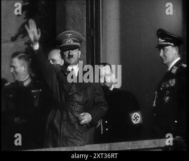 Adolf Hitler, der deutsche Führer, grüßte die Menge mit Hermann Göring und drei männlichen deutschen Offizieren auf dem Balkon des Kanzleramtes in der Wilhelmstraße, Berlin, 1937. "Der Anführer kehrt von seinem Besuch in Italien zurück... den Menschen wird gesagt, dass der Anführer nicht nur ein Mann ist, sondern ein makelloser Gott, und er muss als solcher behandelt werden - und so behandelt werden, wie er ist. Nicht die Rückkehr eines erobernden Helden, denn der Held hat sich noch nicht auf seine wahren Eroberungen gemacht. Nein, das ist nur die Rückkehr von Deutschlands Lieblingssohn. Etwas Neues. Etwas und jemand von treibender Kraft und Einfluss. Das, es sei denn, es wäre zerstört Stockfoto