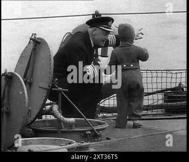 Ein Schiffskapitän, der auf die Weißen Klippen von Dover zeigt, um der jungen Prinzessin Beatrix von den Niederlanden zu zeigen, wie sie 1940 nach Großbritannien flüchten. Zweiter Weltkrieg. "...aber irgendwie haben sie es geschafft. Er machte es so, dass ein britischer Offizier auf eine kleine niederländische Prinzessin hinweisen konnte, die White Cliffs of Dover. Die Klippen eines Landes, das heute die einzige Hoffnung für die Besiegten war, war also das Haus von Orange (d. h. die niederländische Königsfamilie), das von den Niederlanden in das Land transferiert wurde, das der alte niederländische Admiral Van Trump einst zu erobern hoffte. Aus „Time to Remember – Run Rabbit Run“, 1940 (Reel 2); Dokumentarfilm A Stockfoto