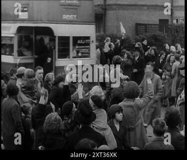 Frauen, Kinder und Männer winken auf Wiedersehen zu Kindern, die mit Bus, 1939 evakuiert werden. Aus „Time to Remember – The Reluctant Warriors“, 1939 (Reel 3); Dokumentarfilm über Ereignisse von 1939 – Vorbereitungen für den Krieg und dann Feindseligkeiten brechen aus. Stockfoto