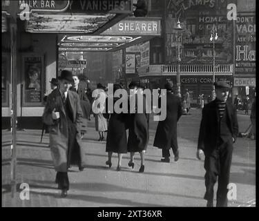 Männer und Frauen gehen durch den Leicester Square mit dem Leicester Corner Restaurant im Hintergrund und verschiedenen Werbespots, darunter für Haig Whiskey, 1939. Aus „Time to Remember – The Reluctant Warriors“, 1939 ( Reel 2); Dokumentarfilm über Ereignisse von 1939 – Vorbereitungen für den Krieg und dann Feindseligkeiten brechen aus. Stockfoto