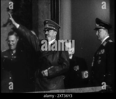 Adolf Hitler, der deutsche Führer, grüßte die Menge mit Hermann Göring und drei männlichen deutschen Offizieren auf dem Balkon des Kanzleramtes in der Wilhelmstraße, Berlin, 1937. "Der Anführer kehrt von seinem Besuch in Italien zurück... den Menschen wird gesagt, dass der Anführer nicht nur ein Mann ist, sondern ein makelloser Gott, und er muss als solcher behandelt werden - und so behandelt werden, wie er ist. Nicht die Rückkehr eines erobernden Helden, denn der Held hat sich noch nicht auf seine wahren Eroberungen gemacht. Nein, das ist nur die Rückkehr von Deutschlands Lieblingssohn. Etwas Neues. Etwas und jemand von treibender Kraft und Einfluss. Das, es sei denn, es wäre zerstört Stockfoto