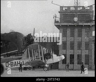 Verschiedene Flugzeuge, die am Boden entlang Rollen, 1920er Jahre Ein Handley Page W8 Doppelflugzeug der belgischen Fluggesellschaft Sabena neben dem Kontrollturm am Flughafen Croydon, London. Aus „Time to Remember – Fast and Far in the Twenties“, 1927 (Reel 2 – Record A); ein Blick auf die Besessenheit von Geschwindigkeit und Fahrt in den späten 1920er Jahren Stockfoto