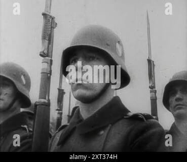 Deutsche Soldaten, 1941. Zweiter Weltkrieg. "...der Feind auf der anderen Seite des Kanals [d. h. Hitler] war gezwungen, seinen fruchtbaren Geist anderen und noch ehrgeizigeren Konzepten zuzuwenden... die Nazi-Hierarchie wandte ihre Machenschaften - ohne ein wenig Angst - auf die bedeutsame Operation Barbarossa." Aus „Time to Remember – Operation Barbarossa“, 1941 (Rolle 1); Dokumentarfilm über Ereignisse von 1941, an der Ostfront und in Pearl Harbour. Stockfoto
