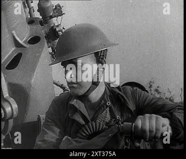 Nahaufnahme eines männlichen britischen Soldaten, der einen Stahlhelm trägt und neben einer Flugabwehrkanone sitzt und mit seiner linken Hand eine Kurbel dreht, 1939. Aus „Time to Remember – The Reluctant Warriors“, 1939 (Reel 1); Dokumentarfilm über Ereignisse von 1939 – Vorbereitungen für den Krieg und dann Feindseligkeiten brechen aus. Stockfoto