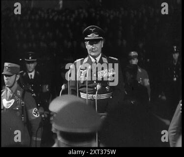 Hermann Göring hielt eine Rede von einem dekorierten Dais am Lehrter Bahnhof in Berlin mit deutschen Soldaten hinter ihm, 1937. Zeremonie für einen Chef. Der Führer [Adolf Hitler] kehrt von seinem Italienbesuch zurück und seine rechte Hand begrüßt ihn im Namen Deutschlands. So wird dem Volk gesagt, dass der Führer nicht nur ein Mann ist, sondern ein makelloser Gott, und er muss als solcher behandelt werden - und als solcher behandelt werden." Aus "Time to Remember - Sense of Values", 1937 (Reel 4); Dokumentarfilm über die Ereignisse von 1937, Krieg im Fernen Osten, Aufbau bis Krieg in Europa. Stockfoto