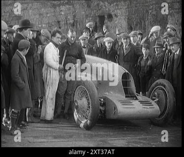 Malcolm Campbell bereitet sein Auto „Bluebird“ vor, beobachtet von einer Menge Zivilisten, 1927. Campbell mit „Bluebird“ in Pendine Sands, Carmarthenshire, bevor er im Februar 1927 den Weltrekord für Landgeschwindigkeiten brechen konnte. Aus "Time to Remember - Fast and Far in the zwanziger Jahre", 1927 (Rolle 1); ein Blick auf die Besessenheit von Geschwindigkeit und Reisen in den späten 1920er Jahren Stockfoto