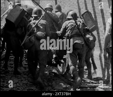 Eine Gruppe männlicher japanischer Soldaten, die in einer Straße in Shanghai 1937 eine Waffe über Schutt schieben. „Als Japan aus seiner langen Abgeschiedenheit in die moderne Welt herauskam, suchten seine Führer, inspiriert von den alten Traditionen, die alle zum Sterben für die Ehre ihres Landes aufforderten, nach Expansion und Eroberung. Die westliche Welt hatte ihnen das Schlachtschiff, die Waffe und die Bombe gegeben. Jetzt suchten sie nach der Chance, sie zu nutzen. Japan hatte eine Armee, groß und hervorragend ausgebildet. Auch eine Marine, mächtig und ehrgeizig. Es ging nur darum, wann und wo. Ein Morgen im Jahr 1937, die Küste Chinas nahe Shanghai. Stockfoto