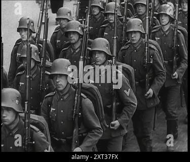 Ein Regiment männlicher deutscher Soldaten marschierte entlang einer deutschen Straße, 1939. Aus „Time to Remember – The Reluctant Warriors“, 1939 (Reel 4); Dokumentarfilm über Ereignisse von 1939 – Vorbereitungen für den Krieg und dann Feindseligkeiten brechen aus. Stockfoto