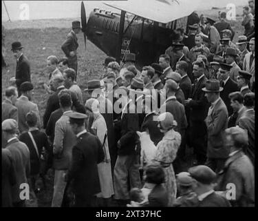 Jim Mollison ging mit einer großen Menschenmenge zu seinem Flugzeug, 1930er Aus "Time to Remember - Some People in the Thirties", 1930er Jahre (Reel 2); Dokumentarfilm über die 1930er Jahre, der sich auf berühmte Charaktere dieser Zeit konzentriert. Stockfoto