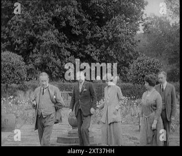 Der britische Premierminister Stanley Baldwin Walking in the Garden at Chequers, das Landhaus des britischen Premierministers mit Lucy Baldwin und Freunden, 1924. Aus "Time to Remember - A Trip to Europe", 1924 (Rolle 4); ein Blick auf das politische und soziale Leben in Europa und darüber hinaus im Jahr 1924. Stockfoto