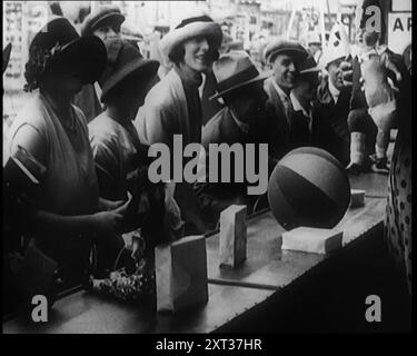 Eine Menschenmenge, die ein Spiel spielt, in dem sie einen Ballon durch Drehen des Griffs auflegen müssen, 1924. Aus "Time to Remember - A Trip to Europe", 1924 (Rolle 3); ein Blick auf das politische und soziale Leben in Europa und darüber hinaus im Jahr 1924. Stockfoto