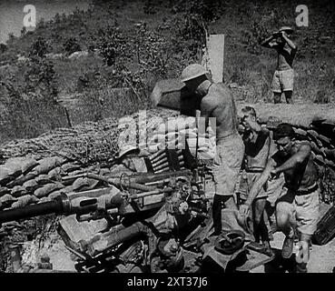 Commonwealth-Truppen laufen zu einer Flugabwehrkanone, 1941. Der zweite Weltkrieg: Japan greift alliierte Truppen an. "Auf den Philippinen, in Singapur, in Hongkong, in Birma, in Java und Sumatra - Flammen inmitten der Palmen. Zerstörung, Verzweiflung, Rückzug. Aus „Time to Remember – Operation Barbarossa“, 1941 (Reel 4); Dokumentarfilm über Ereignisse von 1941, an der Ostfront und in Pearl Harbour. Stockfoto