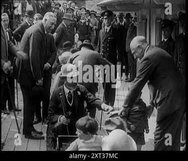 König Georg V. aus Großbritannien sitzt auf einem Modellzug mit einer Menschenmenge. Ein männliches Kind wird von einem männlichen Zivilisten, wie andere lächeln, 1924 auf den Sitz vor dem König gestellt. Aus "Time to Remember - A Trip to Europe", 1924 (Rolle 3); ein Blick auf das politische und soziale Leben in Europa und darüber hinaus im Jahr 1924. Stockfoto