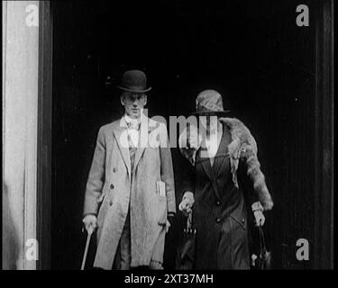 Ein männlicher Zivilist und weiblicher Zivilist aus einem Gebäude, 1924. Aus "Time to Remember - A Trip to Europe", 1924 (Rolle 3); ein Blick auf das politische und soziale Leben in Europa und darüber hinaus im Jahr 1924. Stockfoto