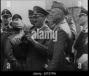 Adolf Hitler hielt ein Paar Ferngläser und stand mit einer Gruppe deutscher Offiziere, 1939. Aus „Time to Remember – The Reluctant Warriors“, 1939 (Reel 3); Dokumentarfilm über Ereignisse von 1939 – Vorbereitungen für den Krieg und dann Feindseligkeiten brechen aus. Stockfoto