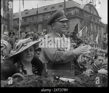 Nahaufnahme eines deutschen Nazi-Parteifunktionären in einer VIP-Sektion eines Stands mit anderen, die die Parade des Weltkongresses für Freizeit und Freizeit 1936 während sie vorbeizieht, 1938 klatschen. Aus „Time to Remember – Wind Up Week“, 1938 (Reel 1); Dokumentarfilm über 1938 – die Menschen werden sich der wachsenden Bedrohung des Krieges bewusst. Stockfoto