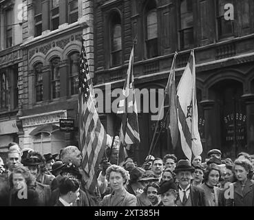 Britische Zivilisten Beobachten, Wie Amerikanische Truppen Durch London Marschieren, 1942. Amerika tritt dem Zweiten Weltkrieg bei. Im Frühjahr marschierten die ersten amerikanischen Einheiten seit 1919 durch Londons Straßen. 1919 wurden sie als Doughboys bezeichnet. Jetzt waren sie GIS, aber genauso willkommen. "Hast du Kaugummi, Kumpel?". Aus „Time to Remember – The End of the Beginning“, 1942 (Reel 1); Dokumentarfilm über Ereignisse von 1942 und Amerikas Eintritt in den Krieg. Stockfoto