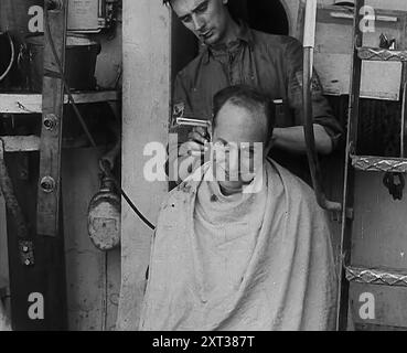 Ein Seemann, der sich die Haare schneiden lässt, 1943. 1943 (Reel 4); Dokumentarfilm über Ereignisse von 1943, insbesondere die Schlacht am Atlantik. Stockfoto