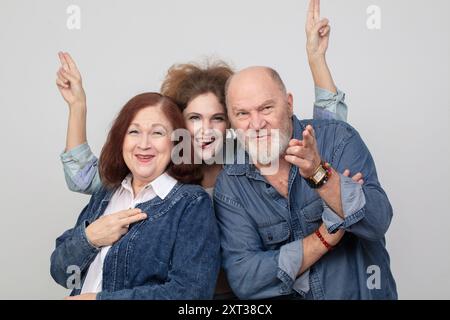 Eltern und Erwachsene Tochter. Ein schönes älteres Paar und ein junges Mädchen umarmen sich, haben Spaß und machen Gesichter vor der Kamera. Stockfoto