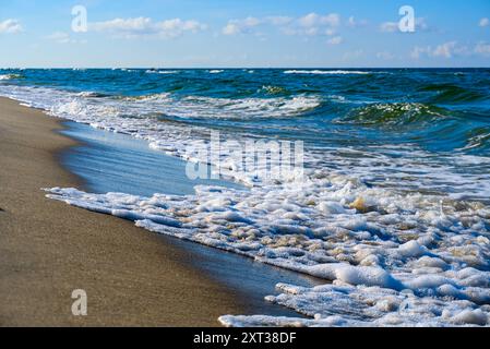 Die Wellen der Ostsee erreichen sanft das Sandufer von Jastarnia auf der Halbinsel Hel unter klarem Himmel. Stockfoto