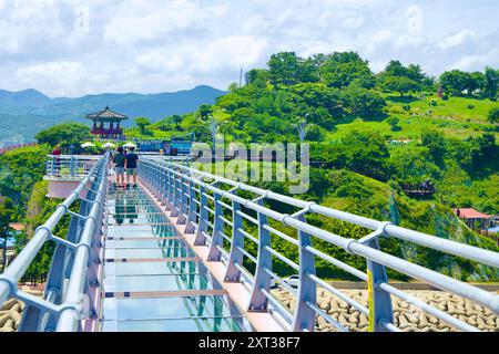 Uljin County, Südkorea - 27. Juli 2024: Besucher spazieren entlang des Deunggi Mountain Skywalk mit Glasboden, mit Blick auf den üppig grünen Park und tr Stockfoto