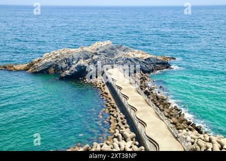 Uljin County, Südkorea - 27. Juli 2024: Ein malerischer Blick auf den Gatbawi Rock und den angrenzenden Betonsteg, der sich bis in die Ostsee erstreckt, bietet einen Stockfoto