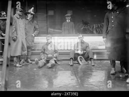 Feuerwehrleute überwinden, U-Bahn-Feuer, 1.6.15, 1915. Zeigt Feuerwehrleute, die auf dem Bürgersteig sitzen, nachdem sie am 6. Januar 1915 einen Brand in einem New York City U-Bahn-Tunnel in der Nähe der West 55th Street und des Broadway bekämpft hatten. Stockfoto