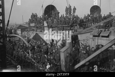 Piloten auf der RMS Mauretania, 1918. Zeigt den Ozeanliner RMS Mauretania in New York City mit amerikanischen Piloten und anderen Truppen, die nach dem Ersten Weltkrieg am 2. Dezember 1918 aus Europa zurückkehrten. Das Schiff ist in blendender Tarnung gemalt. Stockfoto