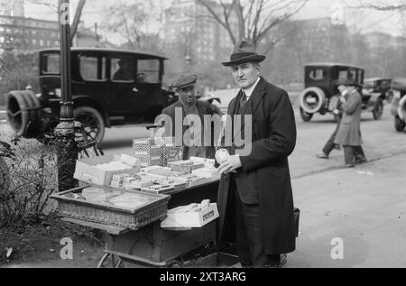 Clarence Eugene Whitehill, zwischen 1915 und 1920. Zeigt den amerikanischen Bass-/Baritonsänger Clarence Whitehill (1871–1932) an einem Straßenverkäufer, an dem Kisten mit Ridleys Broken Candy, Wrigleys Juicy Fruit Gum und anderen Gegenständen aufbewahrt werden. Stockfoto