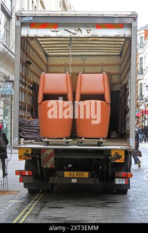 London, Vereinigtes Königreich - 02. April 2010: Entladen von Sesseln Möbel aus Delivery Cargo Truck im Stadtzentrum. Stockfoto