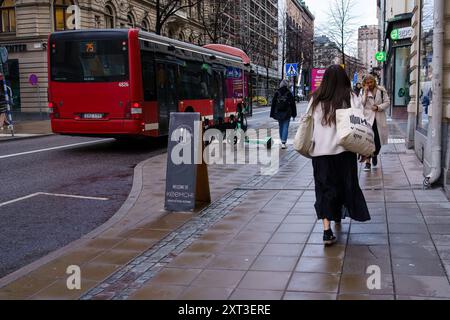 Stockholm, Schweden. April 2024 - Blick von der Straße in die Leute und einen roten Bus Stockfoto