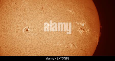 Sonnenflecken auf der Sonnenoberfläche am 13. August 2024. Das Bild wird mit dem Hydrogen Alpha-Wellenband-Solarfilter aufgenommen, um magnetische Oberflächenfelder und -Filamente klar darzustellen und detaillierte Ansichten von zwei großen Sonnenfleckengruppen zu erhalten. Kredit: Malcolm Park/Alamy Stockfoto