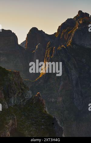 Ein atemberaubender Blick auf die ersten Sonnenstrahlen, die die zerklüfteten Gipfel der Madeira-Berge in einem goldenen Schein baden, und die spektakuläre Natur unterstreicht Stockfoto