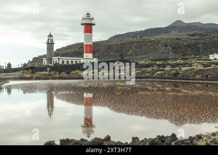 Ein ruhiges Foto, das den ikonischen Leuchtturm von Fuencaliente und die angrenzenden Salzebenen vor dem Hintergrund der vulkanischen La Palma Landschaft festnimmt. Stockfoto