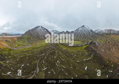 Panorama-Drohnenaufnahme der rauen, wunderschönen Landschaft der Green Highlands in Island mit schneebedeckten Bergen, gewundenen Bächen und pulsierendem m Stockfoto