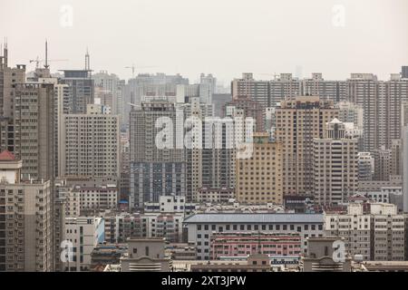 Ein Panoramablick auf Shanghais dicht besiedelte urbane Umgebung, mit Blick auf eine Vielzahl von hohen Wohn- und Geschäftsgebäuden unter einer bewölkten Wolke Stockfoto