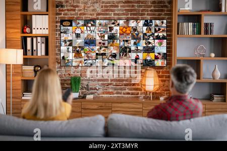 Paare entspannen auf der Couch und schauen Fernsehen im modernen Wohnzimmer Stockfoto