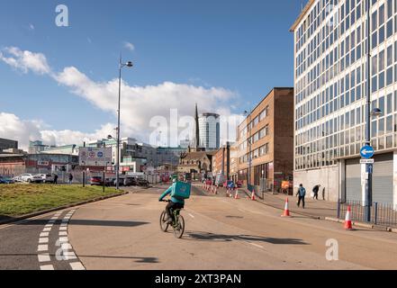 St Martin's Church, Bull Ring, Birmingham, 2023. Allgemeine Ansicht mit Blick nach Nordwesten entlang der Moat Lane, mit St. Martin's Church im Hintergrund und einem Radfahrer zum Mitnehmen im Vordergrund Stockfoto