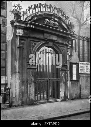 St Olave's Church, Gateway, Hart Street, City of London, Greater London Authority, 1910-1950. Das Kirchhof-Tor der St. Olave's Church in der Seething Lane. Das Tor trägt das Datum 1658 und war ein Favorit von Charles Dickens, der den Kirchhof „Saint Gastly Grim“ nannte und berichtete, dass er ihn eines Nachts nach Mitternacht besucht hatte, um die Schädel zu sehen, die das Tor schmücken. Der Friedhof soll die Grabstätte von Mary Ramsay sein, die vermutlich die Frau ist, die die Pest 1665 nach London gebracht hat. Stockfoto