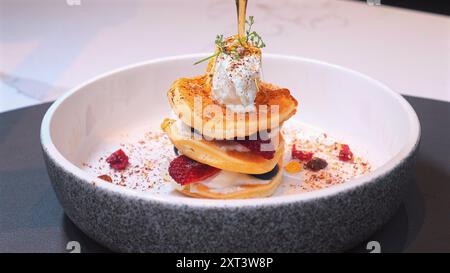 Stapel Gourmet-Pfannkuchen mit Schlagsahne, frischen Beeren, Stockfoto