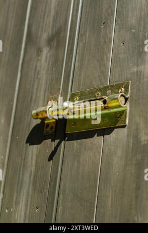 Holztür mit Metallriegelschloss, die Textur und Details in Sicherheit zeigt. Hochwertige Fotos Stockfoto