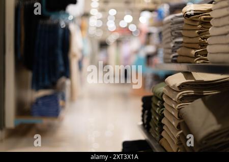 Selektiver Fokus auf Kleidungsstücke, die in Regalen und Bügeln in einem Einkaufszentrum angeordnet sind Stockfoto