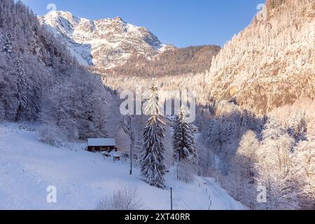 Eine kleine Hütte in einem schneebedeckten Tal, umgeben von den österreichischen Alpen im Winter Stockfoto