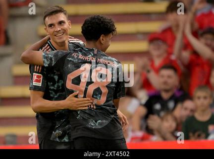 Unterhaching, Deutschland. August 2024. Fußball: Testspiel, FC Bayern - WSG Tirol, Alpenbauer Sportpark. Joao Palhinha (l) und Adam Aznou vom FC Bayern München jubeln als Palhinha 2-0 gegen die WSG Tirol gewinnt. Quelle: Peter Kneffel/dpa/Alamy Live News Stockfoto