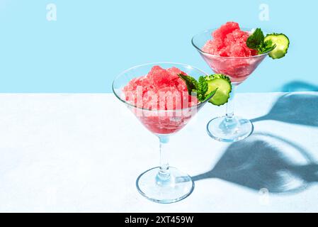 Wassermelonen-Slushie- oder Granita-Cocktail-Drink mit Minze in Gläsern auf hellblauem Hintergrund, Kopierraum. Erfrischendes kaltes, im Sommer rasiertes Eisgetränk oder de Stockfoto