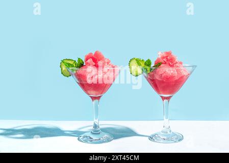 Wassermelonen-Slushie oder Granita-Cocktail mit Minze in Gläsern auf hellblauem Hintergrund. Erfrischendes kaltes, im Sommer rasiertes Eisgetränk, trendiges Shot mit Hard Stockfoto