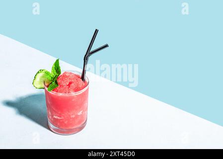 Wassermelonen-Slushie oder Erdbeer-Granita-Cocktail mit Minze im Glas auf zartem blauem Hintergrund, Kopierraum. Erfrischendes kaltes, im Sommer rasiertes Eissorbet d Stockfoto