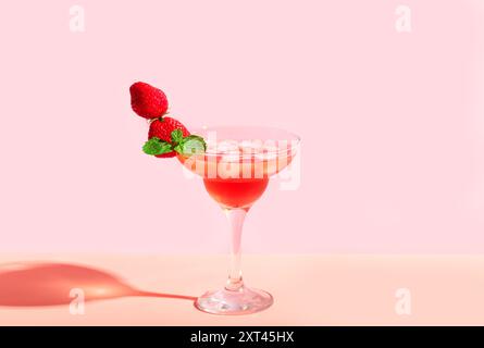 Erdbeermartini oder Daiquiri Cocktail im Glas mit Minze und frischen Erdbeeren auf rosa Pastellhintergrund, Kopierraum. Trendiges Konzept von Cocktail PA Stockfoto